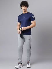 URBAN WOLFS men's navy mesh dry-fit t-shirt worn by model holding a water bottle paired with gray joggers
