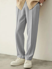 URBAN WOLFS men's light grey baggy joggers with pleated front and relaxed fit styled with beige shirt and white sneakers