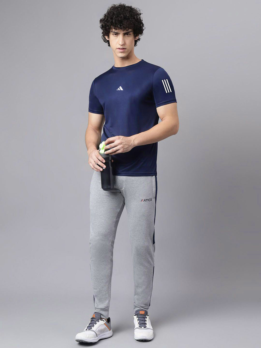 URBAN WOLFS men's navy mesh dry-fit t-shirt worn by model holding a water bottle paired with gray joggers