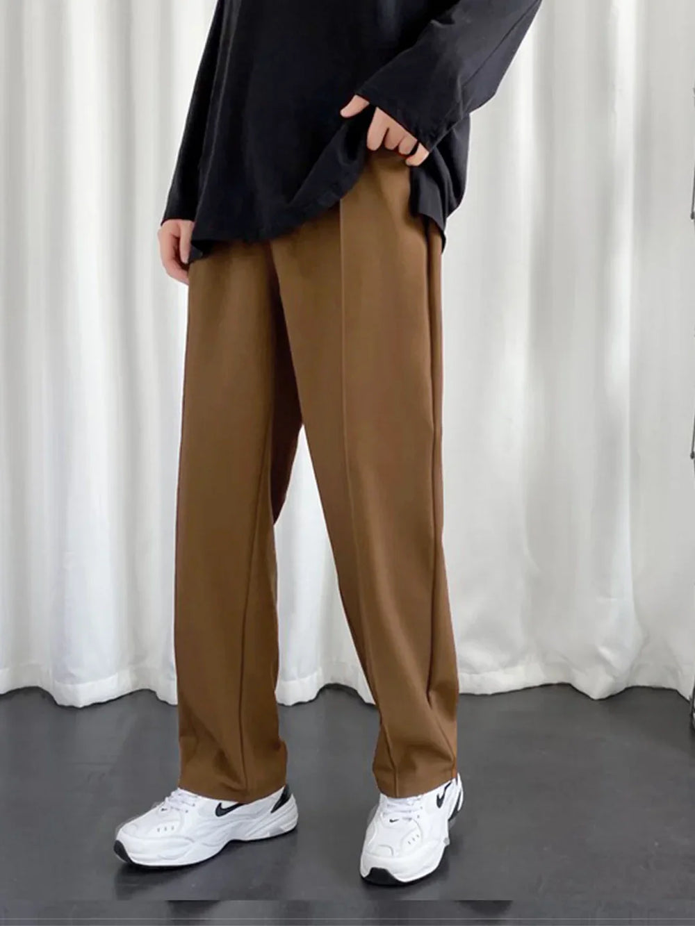 URBAN WOLFS men's brown baggy joggers styled with oversized black top and white sneakers for casual streetwear look